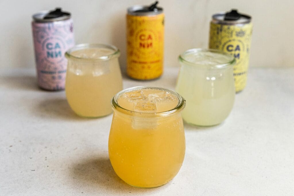 A selection of vibrant CBD-infused drinks showcased in glasses and cans.