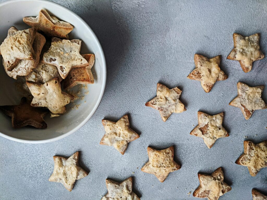 Flat lay of star-shaped homemade cookies in a bowl, perfect for Christmas treats.