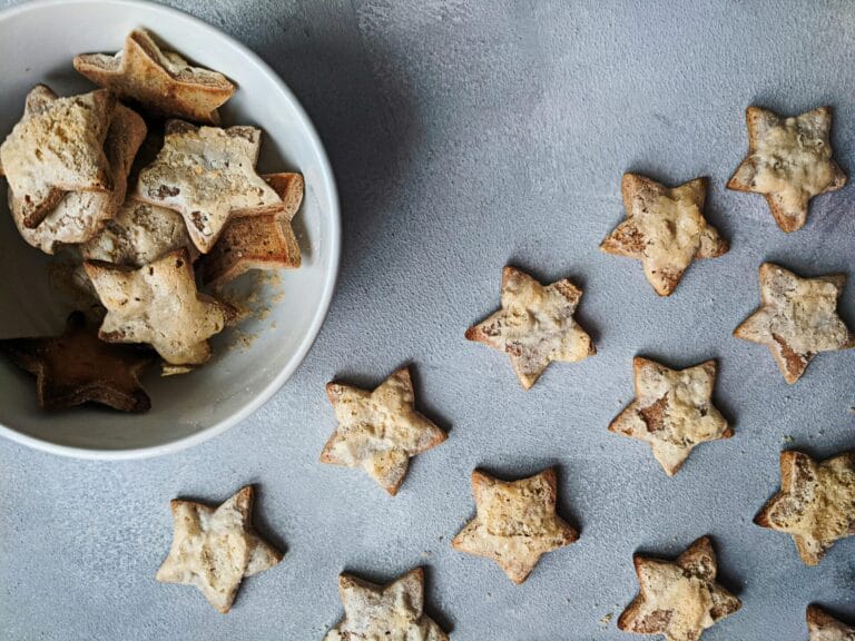 Flat lay of star-shaped homemade cookies in a bowl, perfect for Christmas treats.